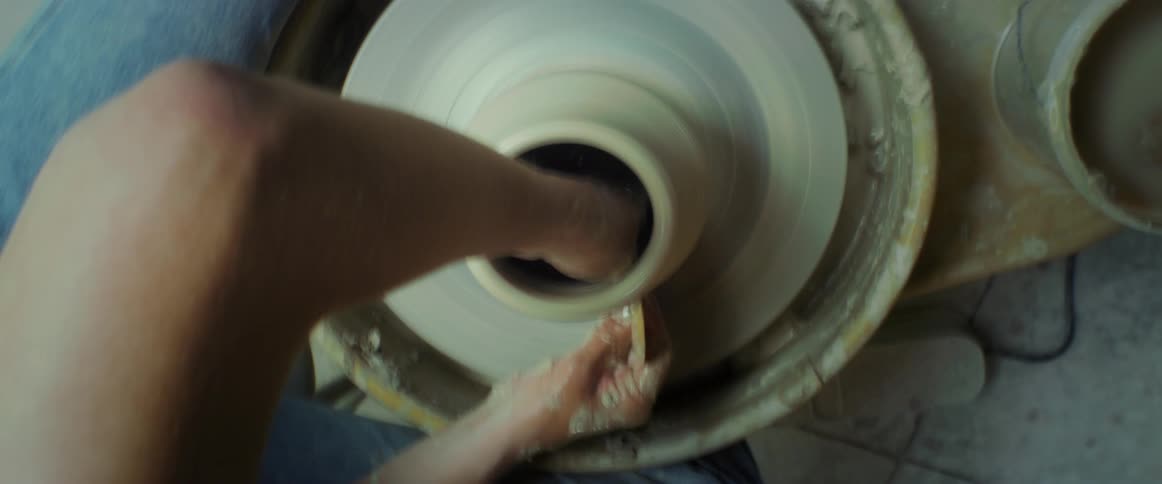 Arm of a carpenter holding a clay vase