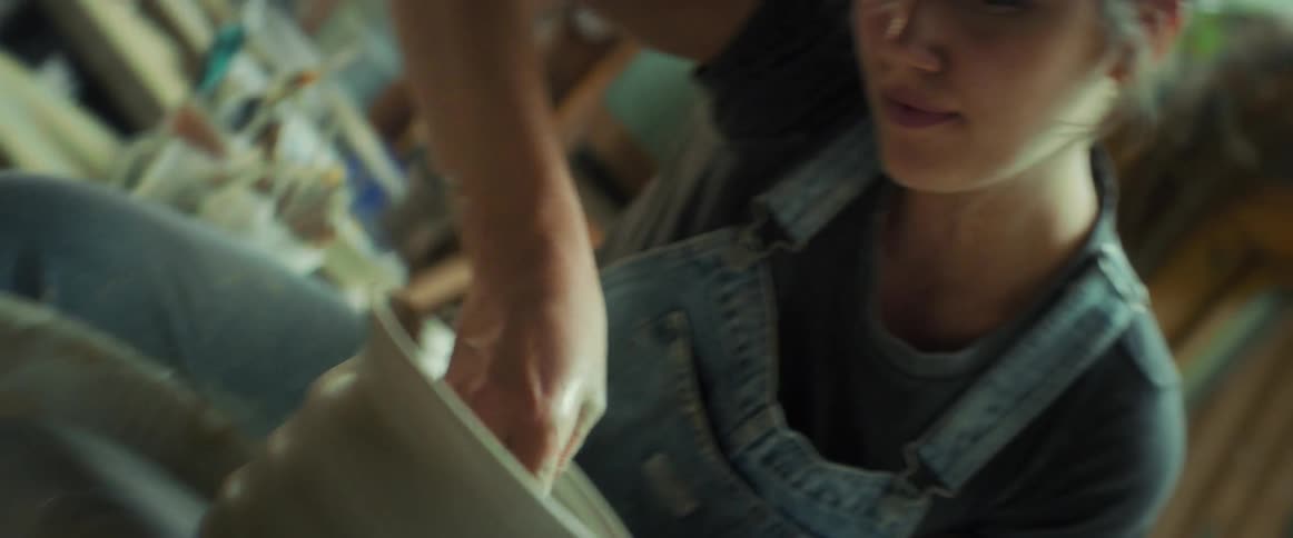Woman with happy facial expression making a handmade clay vase