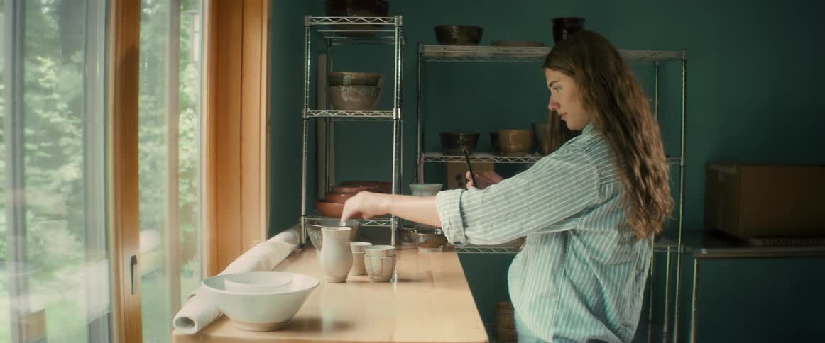 A woman arranges kitchen items to film them