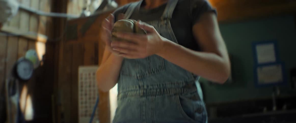Woman indoors preparing a dough of gray clay