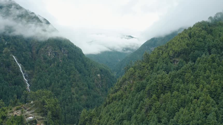A scenic overlook of a lush green valley with a cascading waterfall