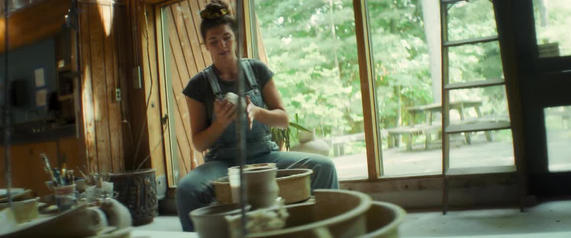 Woman kneading a gray clay dough