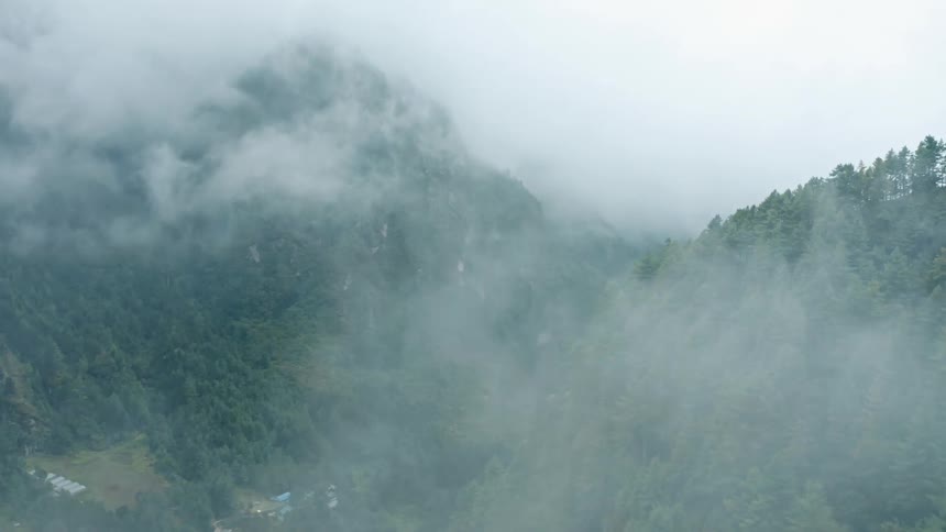 Landscape of mountains with trees and forests on a misty day and in the background a village