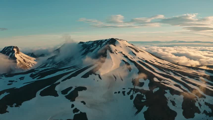 Wisps rise from the side of a mountain