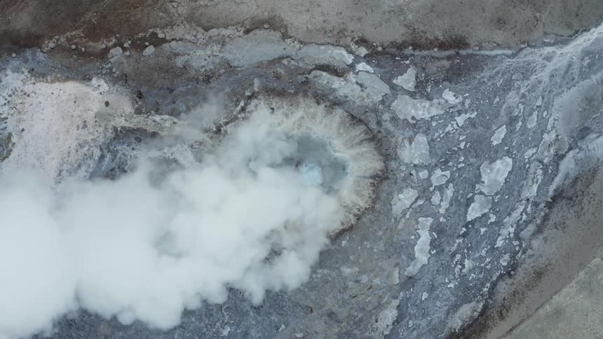 A geyser erupts on a small plain