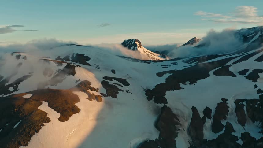 Aerial panorama of snowcovered mountains and reflection of morning sunlight
