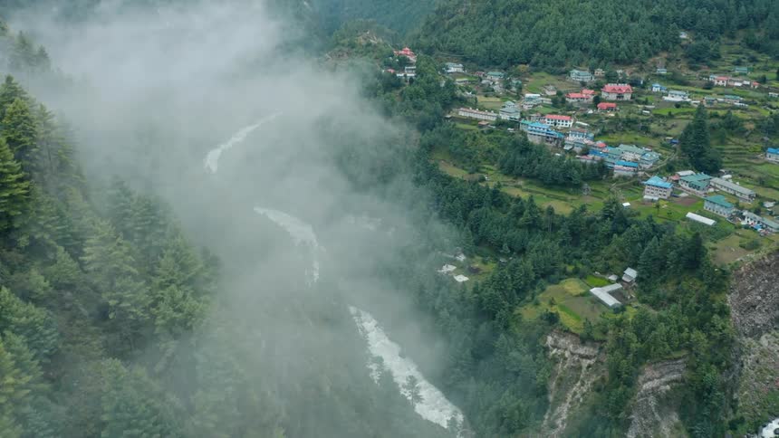 A rural community sits in a mountain valley next to a river