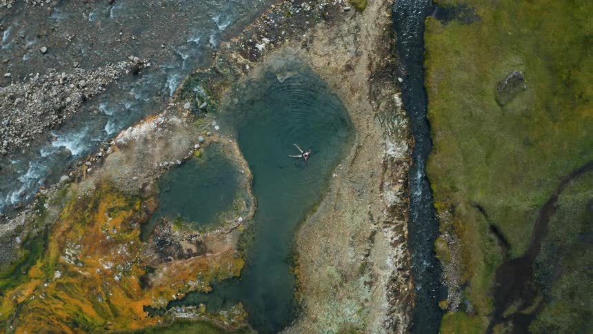 Aerial panorama of a man swimming in a lake surrounded by rivers