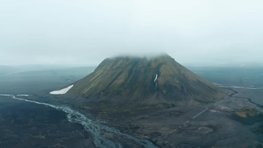 Aerial landscape of a volcano with mosses covered by clouds and a volcanic soil