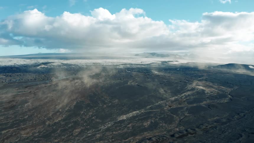 Wisps of steam rise from the ground on a vast plain