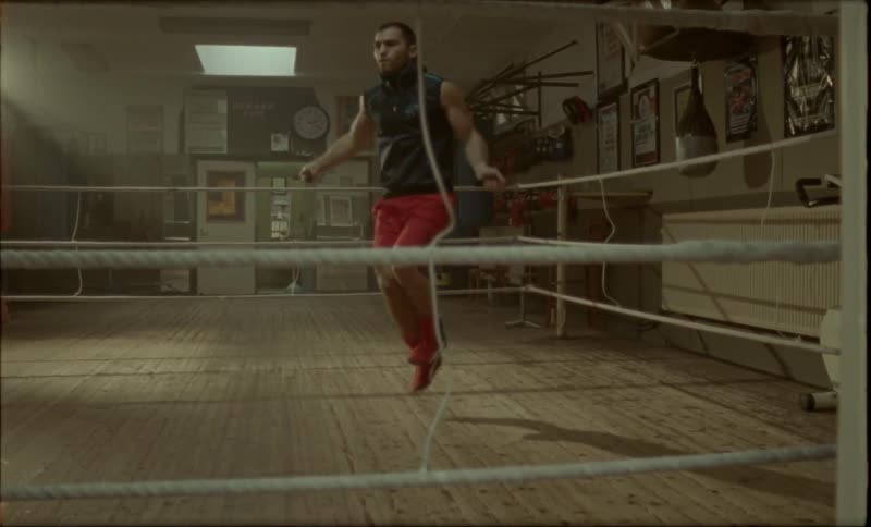 Man training while jumping rope in a wooden gym