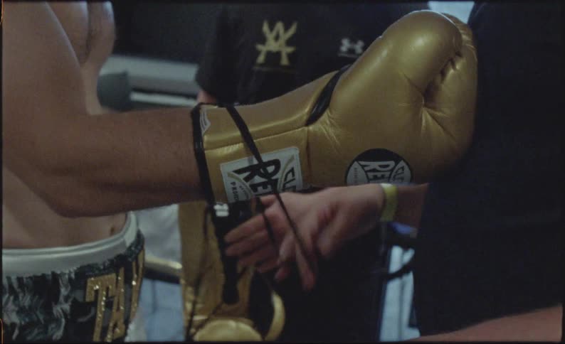 Hands of a man tying a boxing glove on the fighter