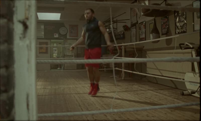 A man jumps rope in a boxing ring in a gym