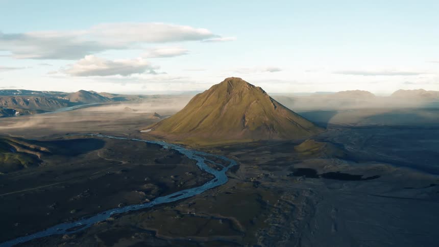 Aerial panorama of a valley with mountains in a morning sky with clouds