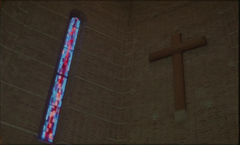A cross hangs on the wall inside the church
