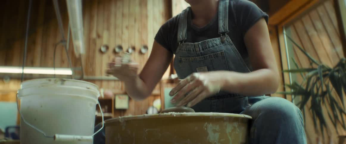 Woman sitting producing a clay vase