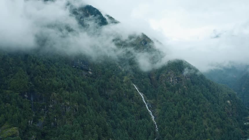 Aerial panorama of a forested mountain with a waterfall