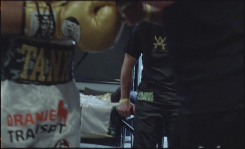 A boxer getting help getting his gloves on his hands