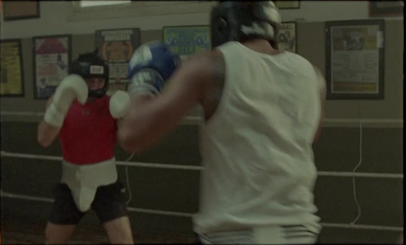 Two boxers fight each other in a ring