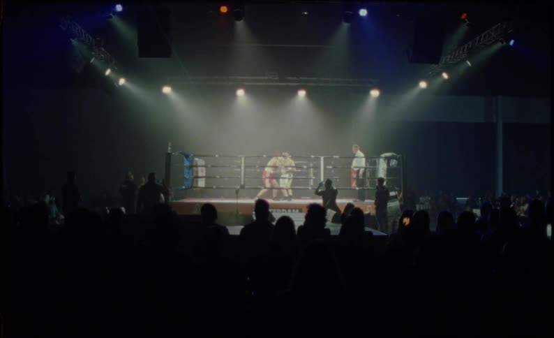 A boxing ring with spectators watching the action on stage