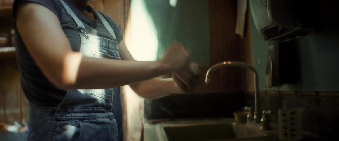 Woman washing her hands and arms in the sink