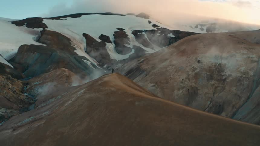 A person walks on a path on top of a mountain