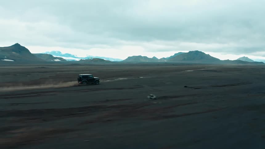 Jeep driving across the desert towards the mountains