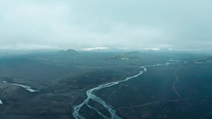 Aerial landscape of a desert floor with extensive river channels on a cloudy day