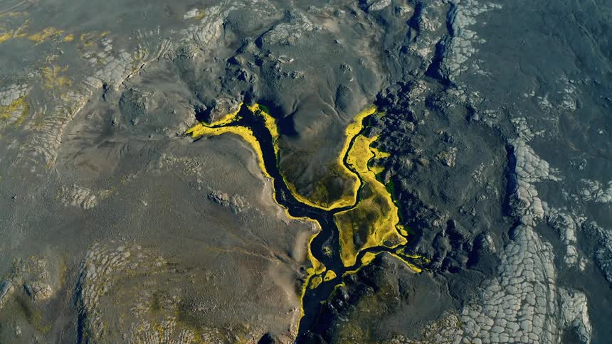 Aerial panorama of fissures in volcanic craters with mosses and water