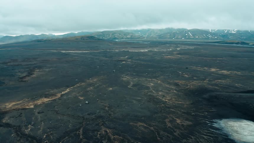 Aerial panorama of a rocky terrain with the silhouette of mountains on the horizon