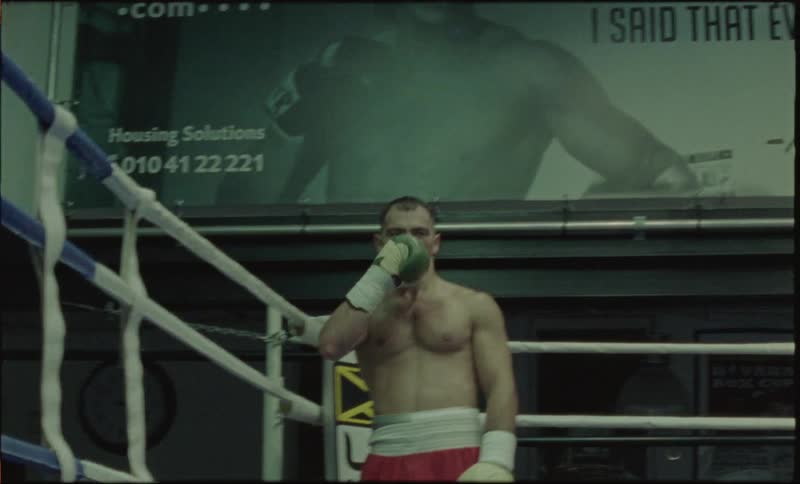 Boxer man in a ring vibrating punching his chest and raising his arm