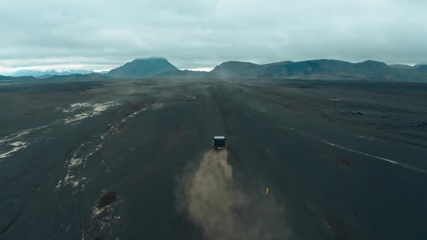 Sports jeep driving through clay soil and mountains around