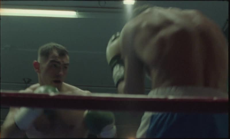 Two men with protective gloves boxing inside a ring