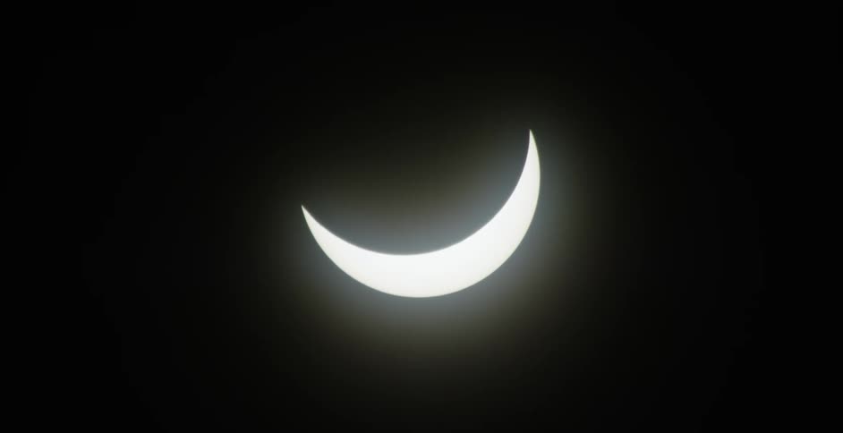 A solar eclipse with the moon partially covering the sun against a dark sky