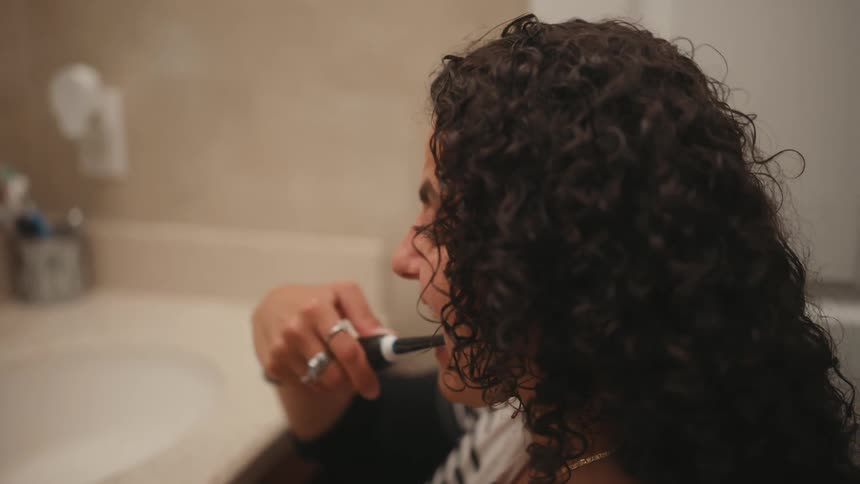 A woman with a disability is brushing her teeth