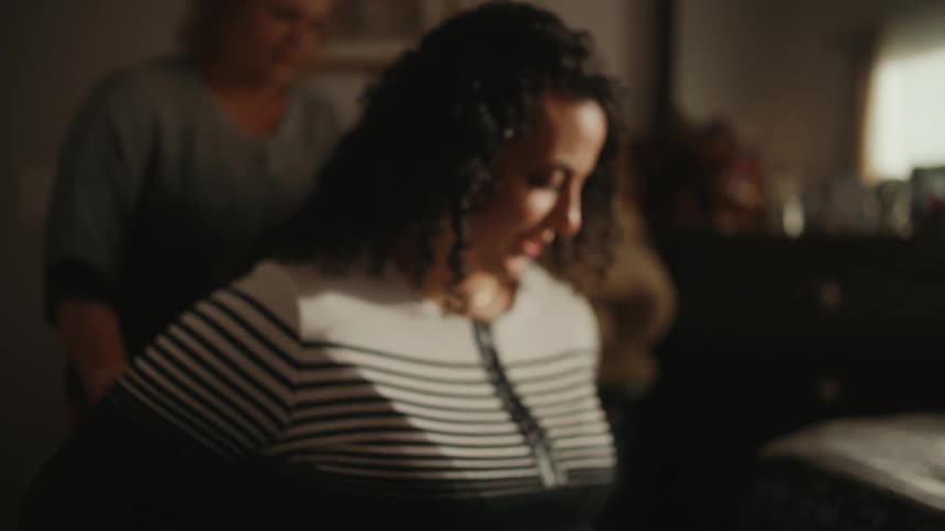 Woman in a wheelchair entering her room with the help of an aide