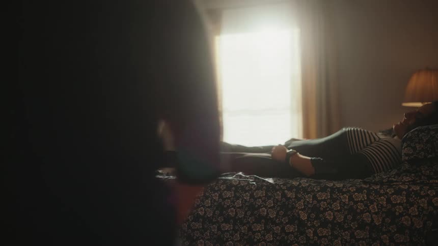 A mother makes sure her disabled daughter is comfortable in bed