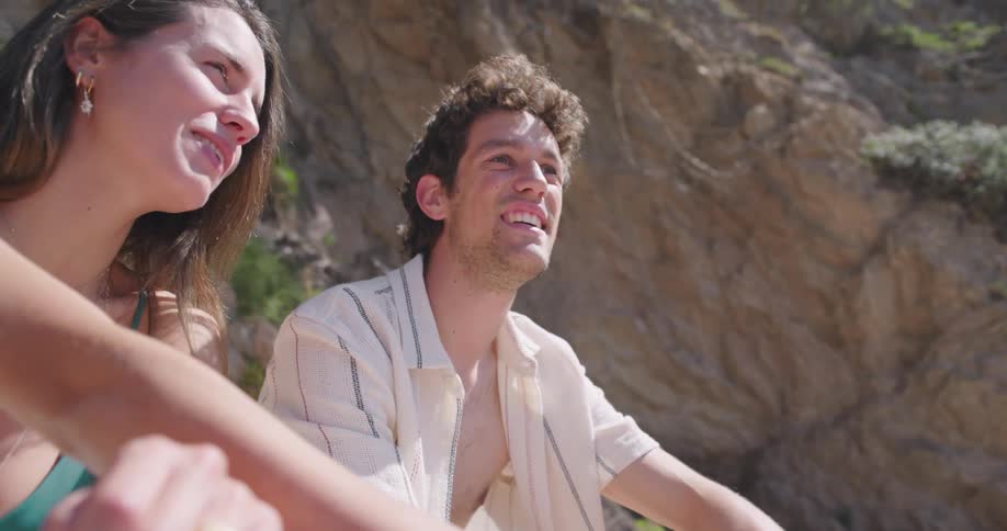 A happy young couple sitting on a beach