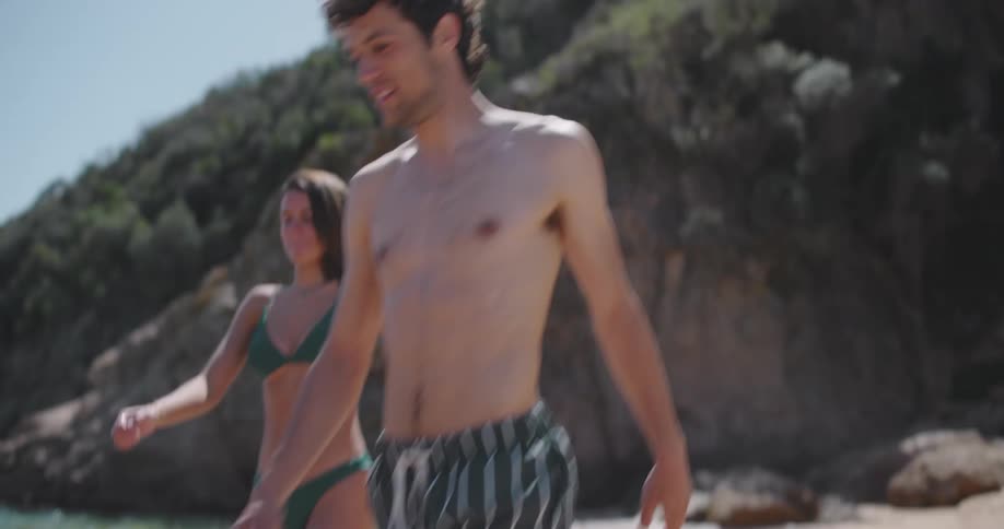 Man and woman walking towards the sea on the beach