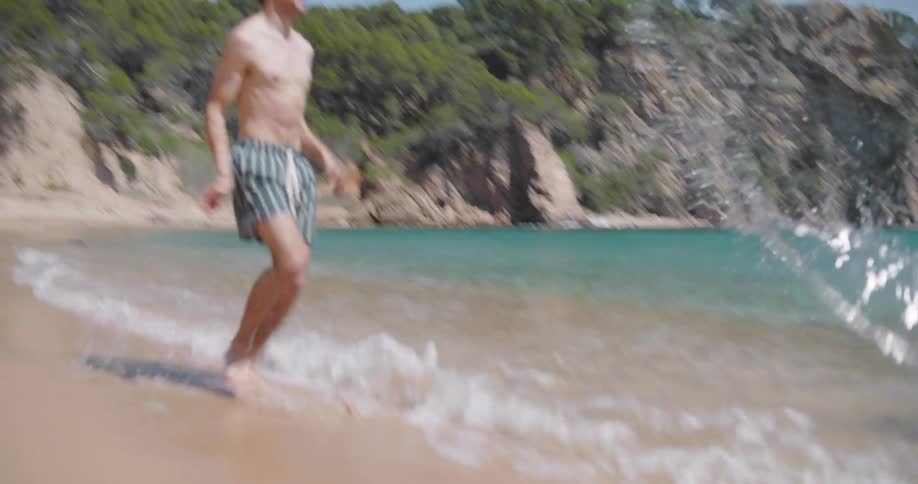 Couple playing on the beach kicking the water at each other