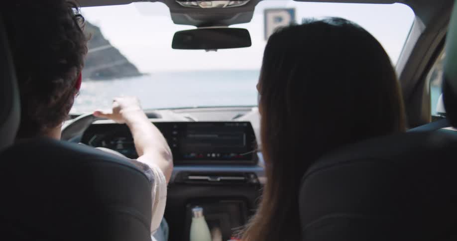 A man and a woman drive to a beach