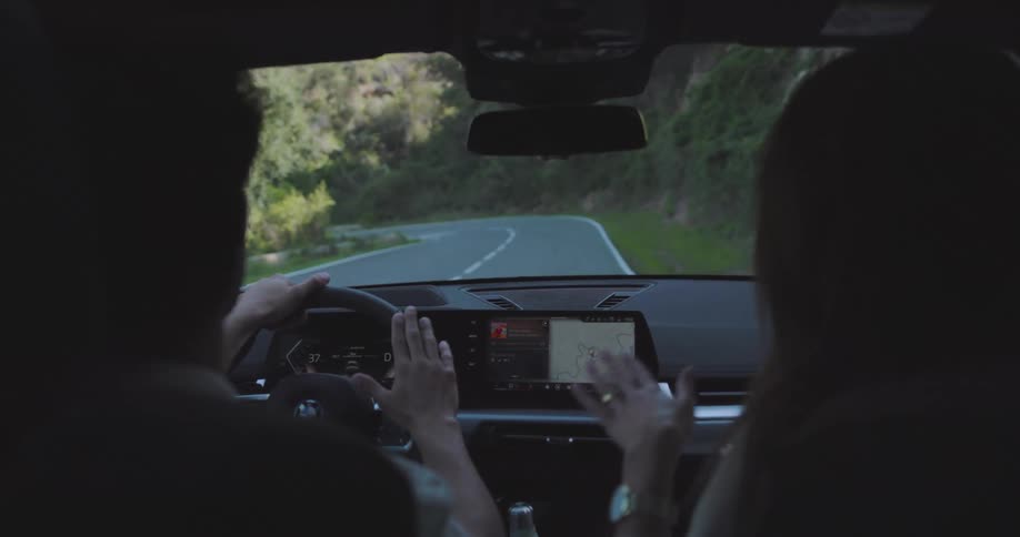 Man driving and woman next to him enjoying the trip