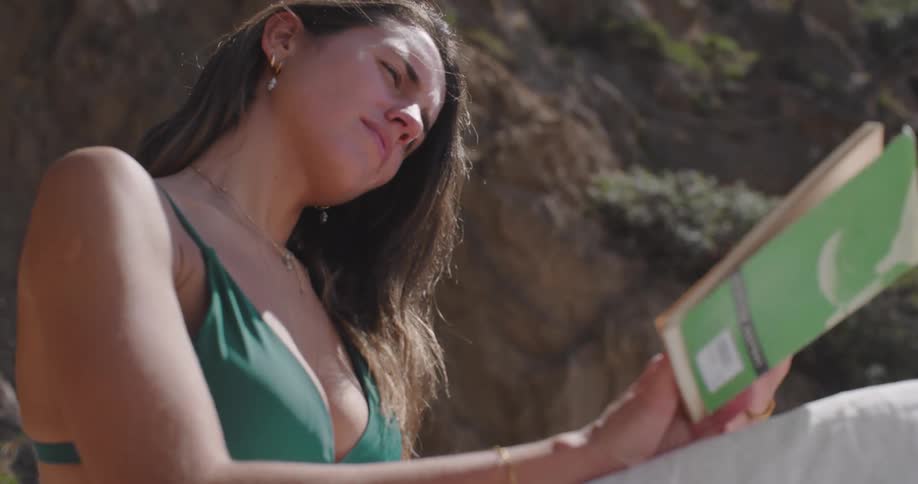 Woman sitting on the beach reading a book
