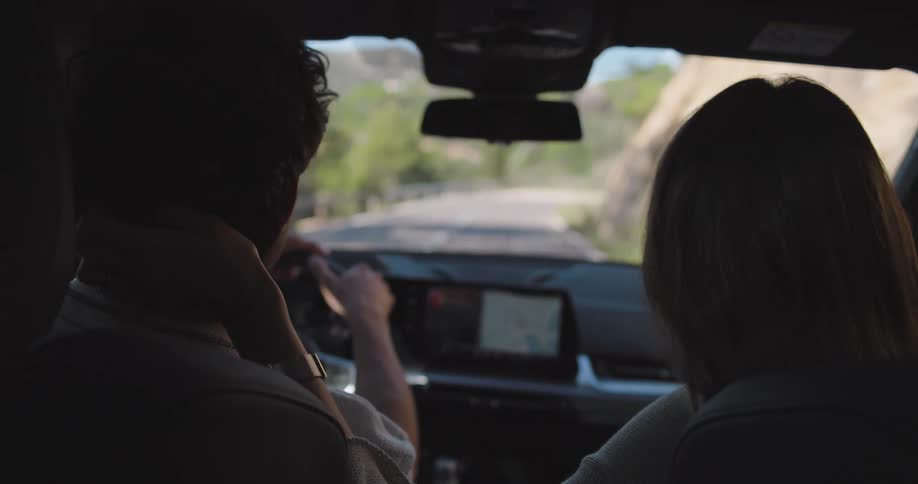 Couple driving along the mountainside passing by a group cycling down