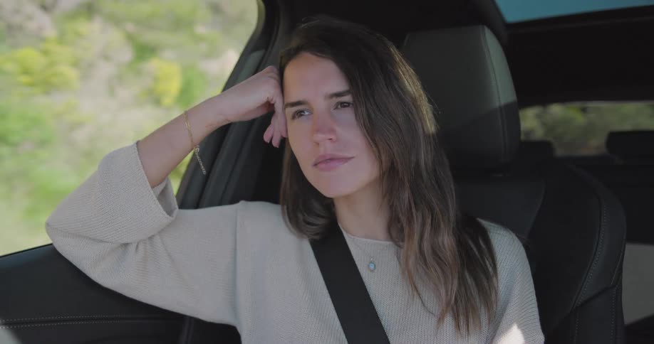 A woman rides in the passenger seat of a car