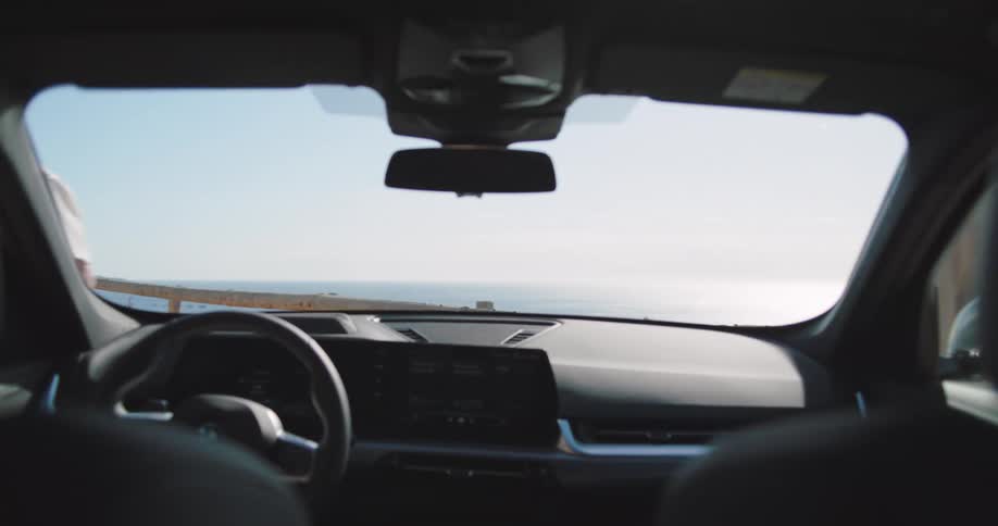 Interior of a car with a couple on the hood talking and then getting into the car