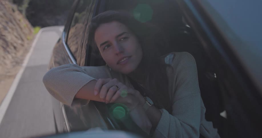 Woman enjoying the scenery from the open car window