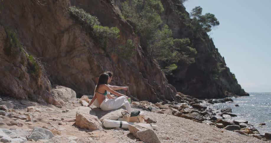 Couple sitting on a rock on a desert beach