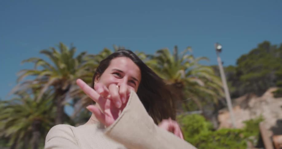A woman walking outdoors while laughing and smiling