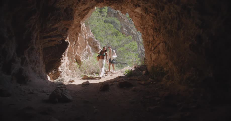 A man and woman walk into the cave